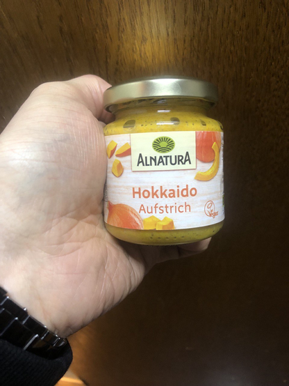 Glas mit orangem Inhalt. Label: [Alnatura-Logo] Hokkaido Aufstrich [Vegan]