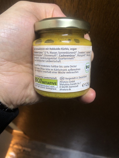 Selbes Glas, Rückseite mit Inhaltsangaben.

Bio-Brotaufstrich mit Hokkaido-Kürbis, vegan
Zutaten: Kürbis* 32%, Wasser, Sonnenblumenöl*, Zwiebeln*, Karotte*, Rohrzucker*, Zitronensaft*, Cashewnüsse*, Maisgrieß*, Meersalz, Gewürze*, Verdickungsmittel: Guarkernmehl*
* aus biologischer Landwirtschaft

Ungeöffnet mindestens haltbar bis: siehe Deckel
Nach dem Öffnen bitte im Kühlschrank aufbewahren und möglichst innerhalb einer Woche verbrauchen. [Bio]
[BIO7 Initiative] Hergestellt in Deutschland
Alnatura GmbH, Mahatma-Gandhi-Str. 7 D-64295 Darmstadt alnatura.de e 125g