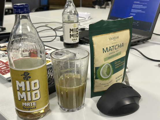 Link: Angebrochene Flasche Mio Mio Mate
Rechts: Tüte mit Matcha-Pulver
Mitte: Glas mit Flüssigkeit in Dünnschissoptik