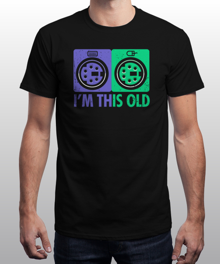 Mann mit T-Shirt Links PS/2-Anschluss in Lila mit Tastatursymbol, rechts in grün mit Maus-Symbol. Drunter: "I'M THIS OLD"