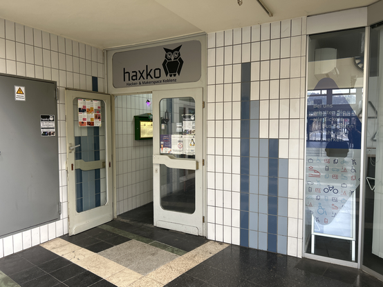 Eingangstür haxko. Doppelflügel links geöffnet.