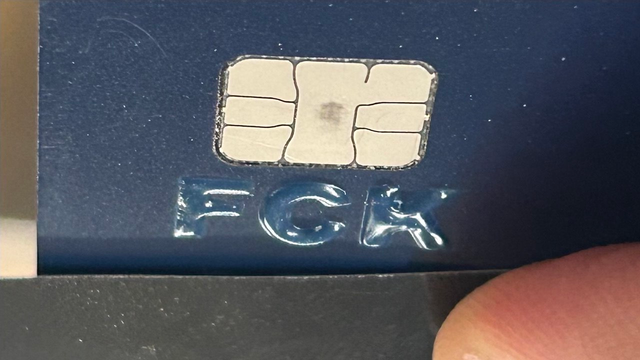 Dunkelblaue Karte mit IC. Drunter die Buchstabenfolge "FCK" als nach vorne stehende "Prägung".
